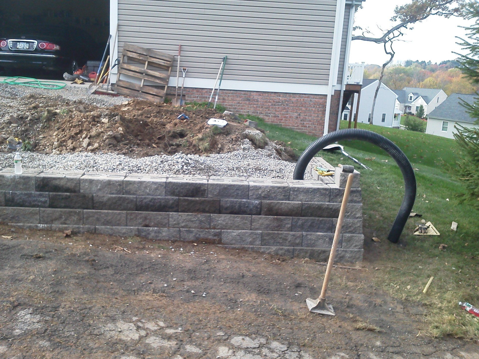 A brick wall is being built in front of a house