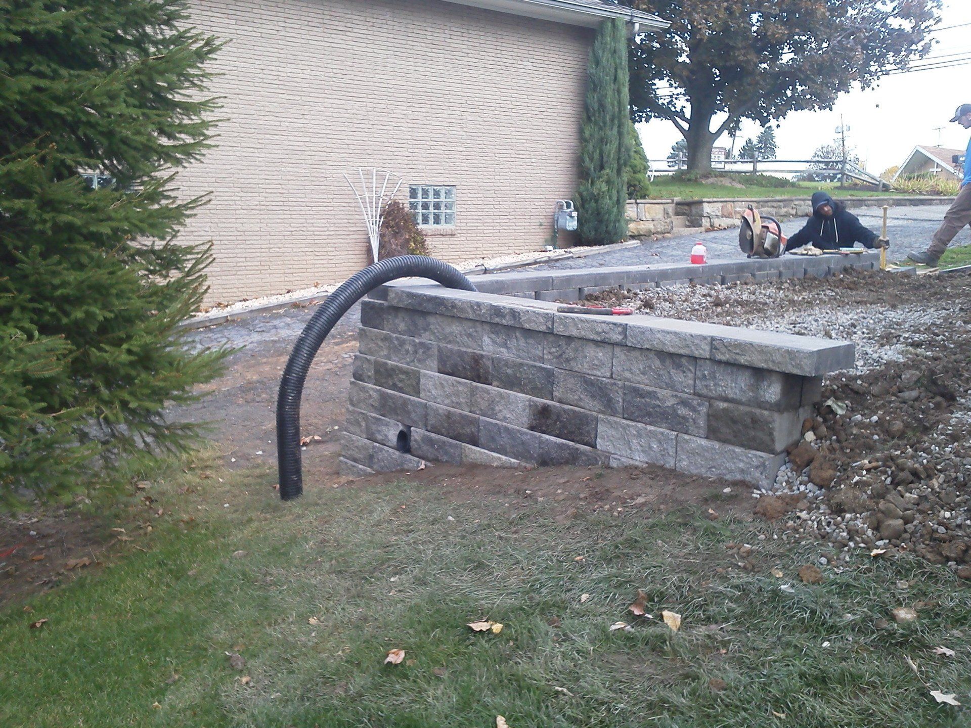 A brick wall is being built in front of a house
