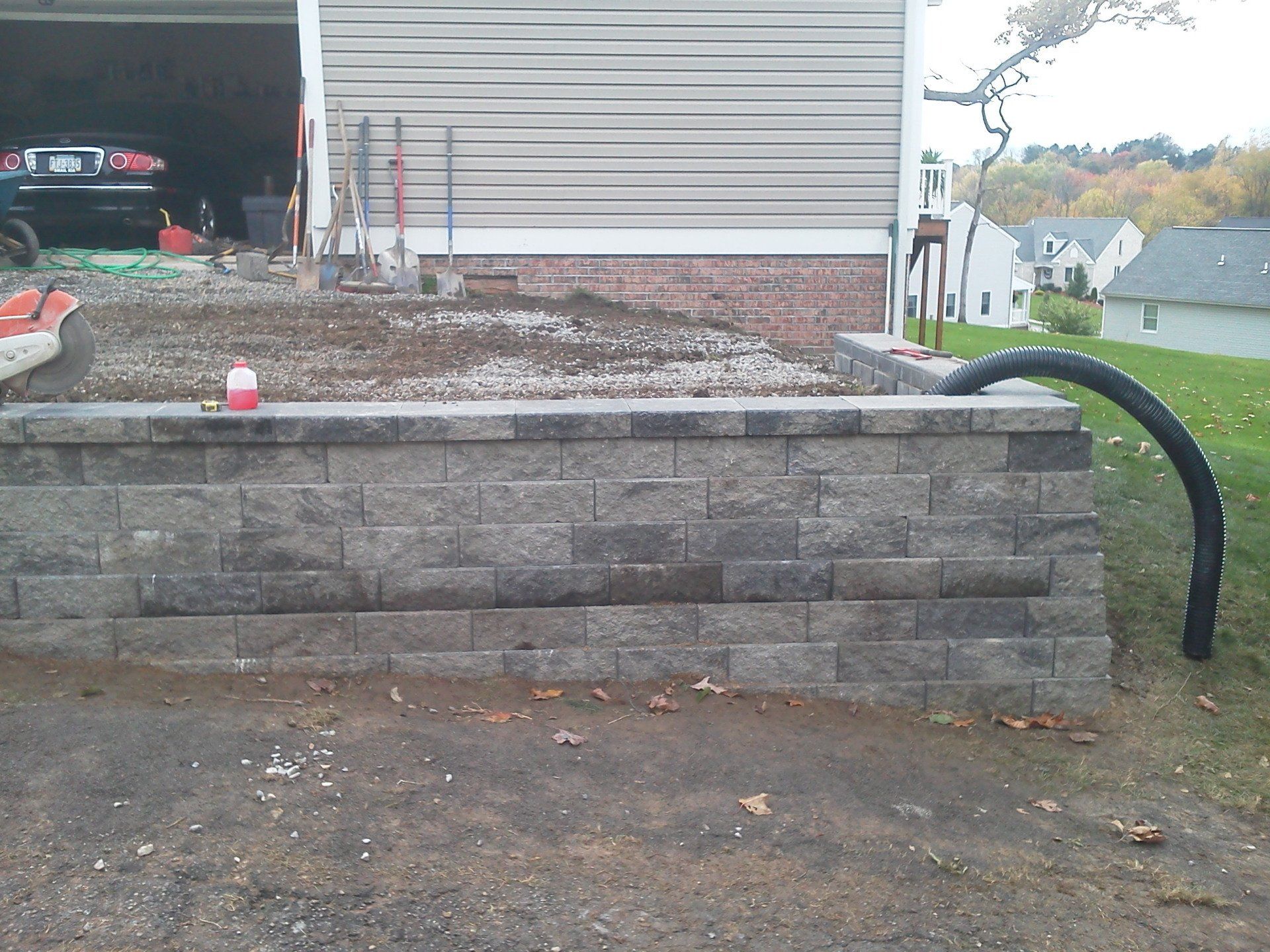 A brick wall is being built in front of a garage
