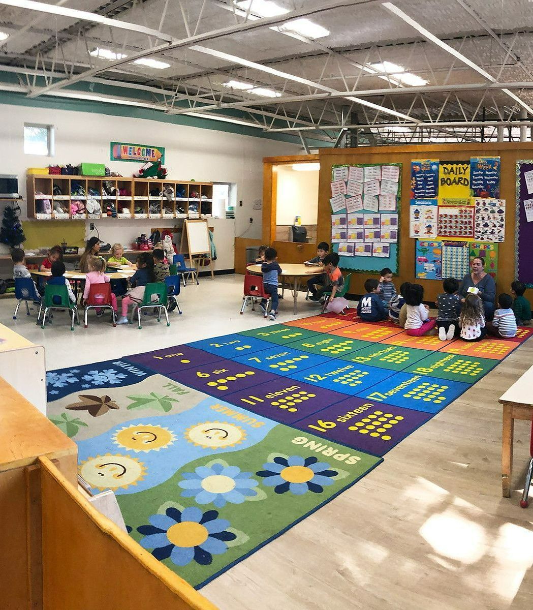 A Large Classroom with Tables and Chairs and A Colorful Rug — Placentia, CA — Towne and Country