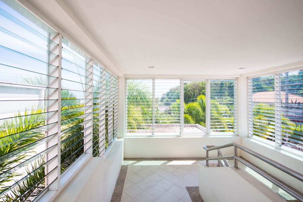 A Large Room With Lots Of Windows And Shutters — G & A Glass & Aluminium in Cluden, QLD