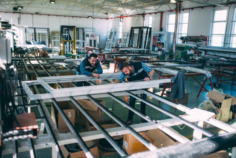 Two Men Are Working on a Metal Structure in a Factory — G & A Glass & Aluminium in Mackay, QLD