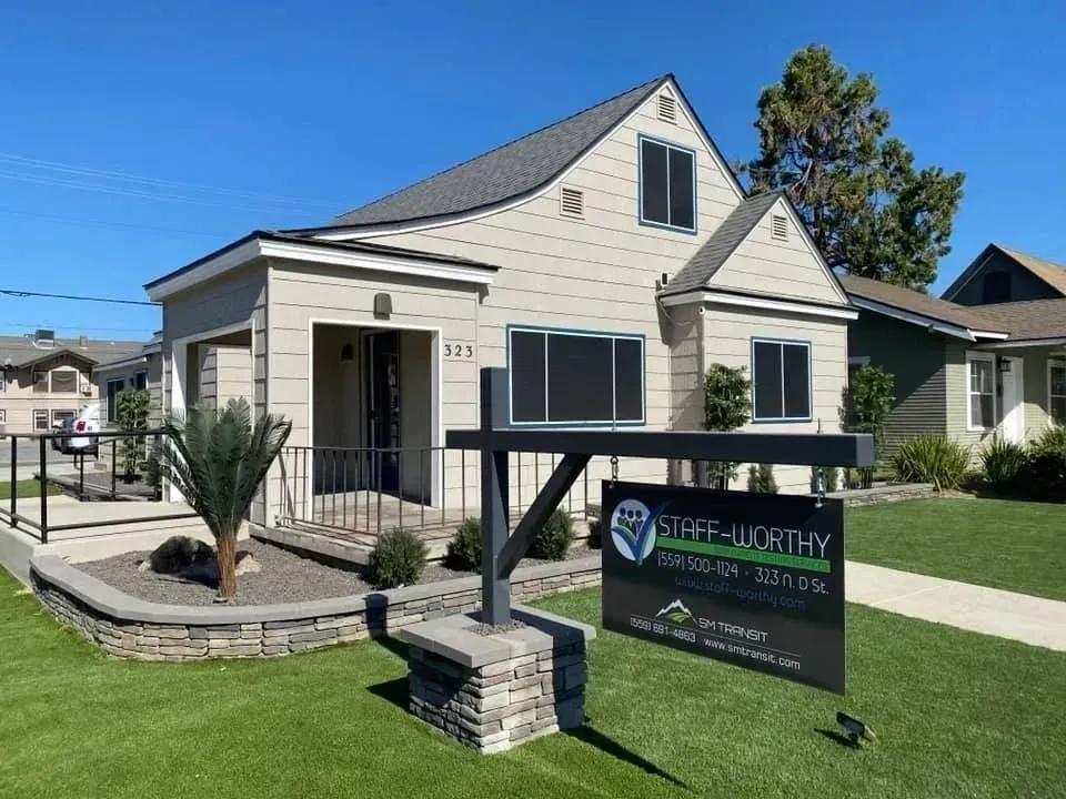 A house with a for sale sign in front of it.