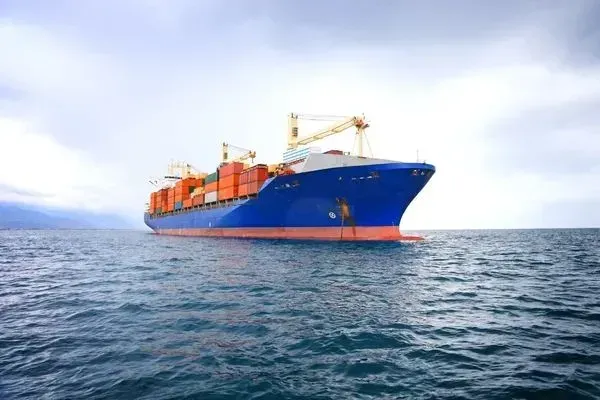 A large container ship is floating on top of a large body of water.