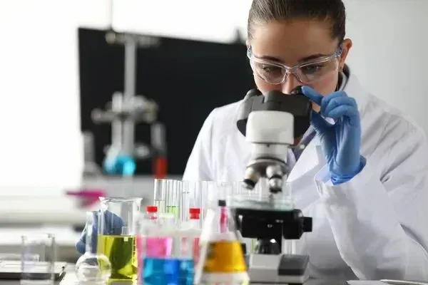 A female scientist is looking through a microscope in a laboratory.