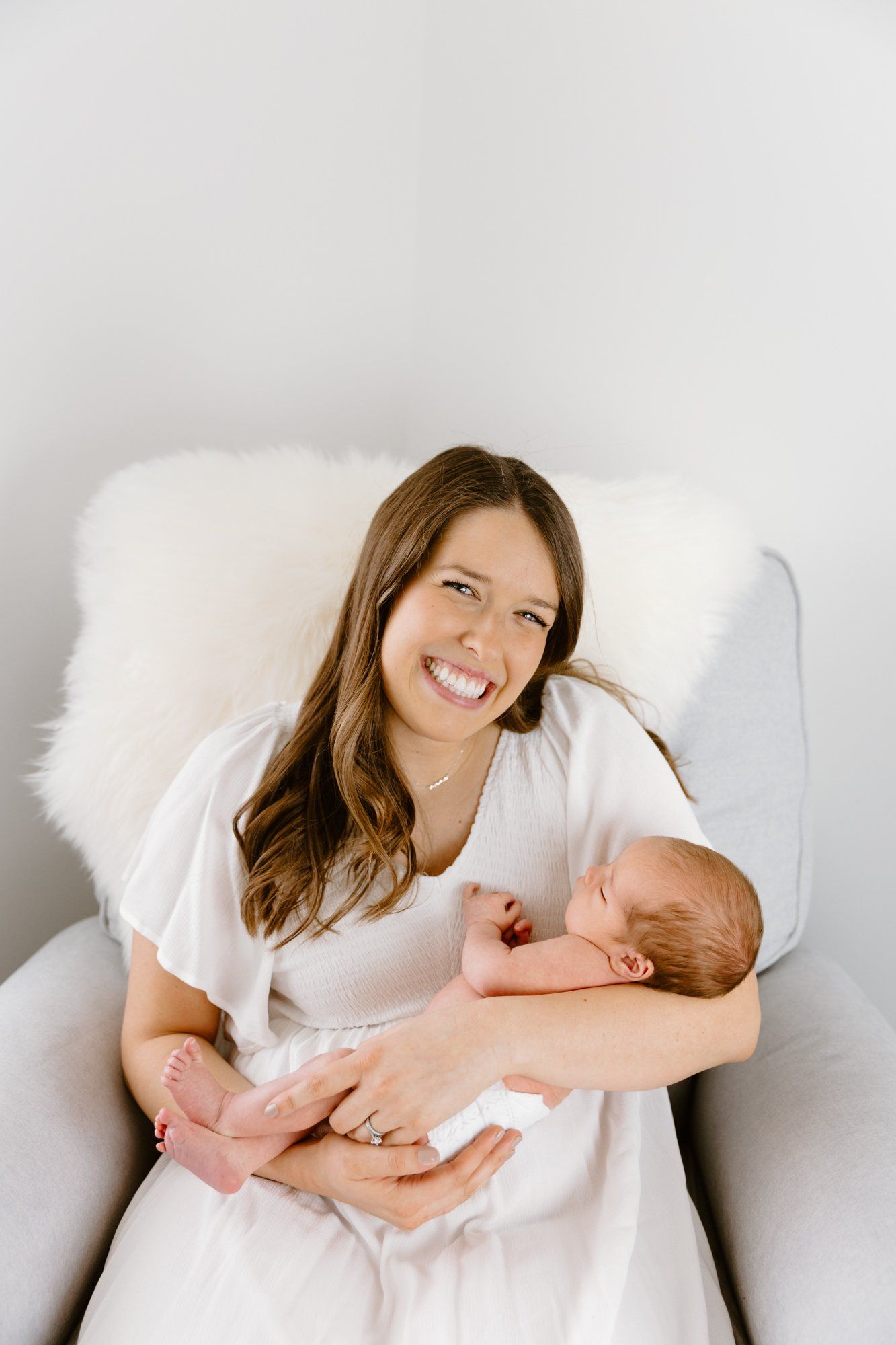 Mom smiles and holds baby in the nursery