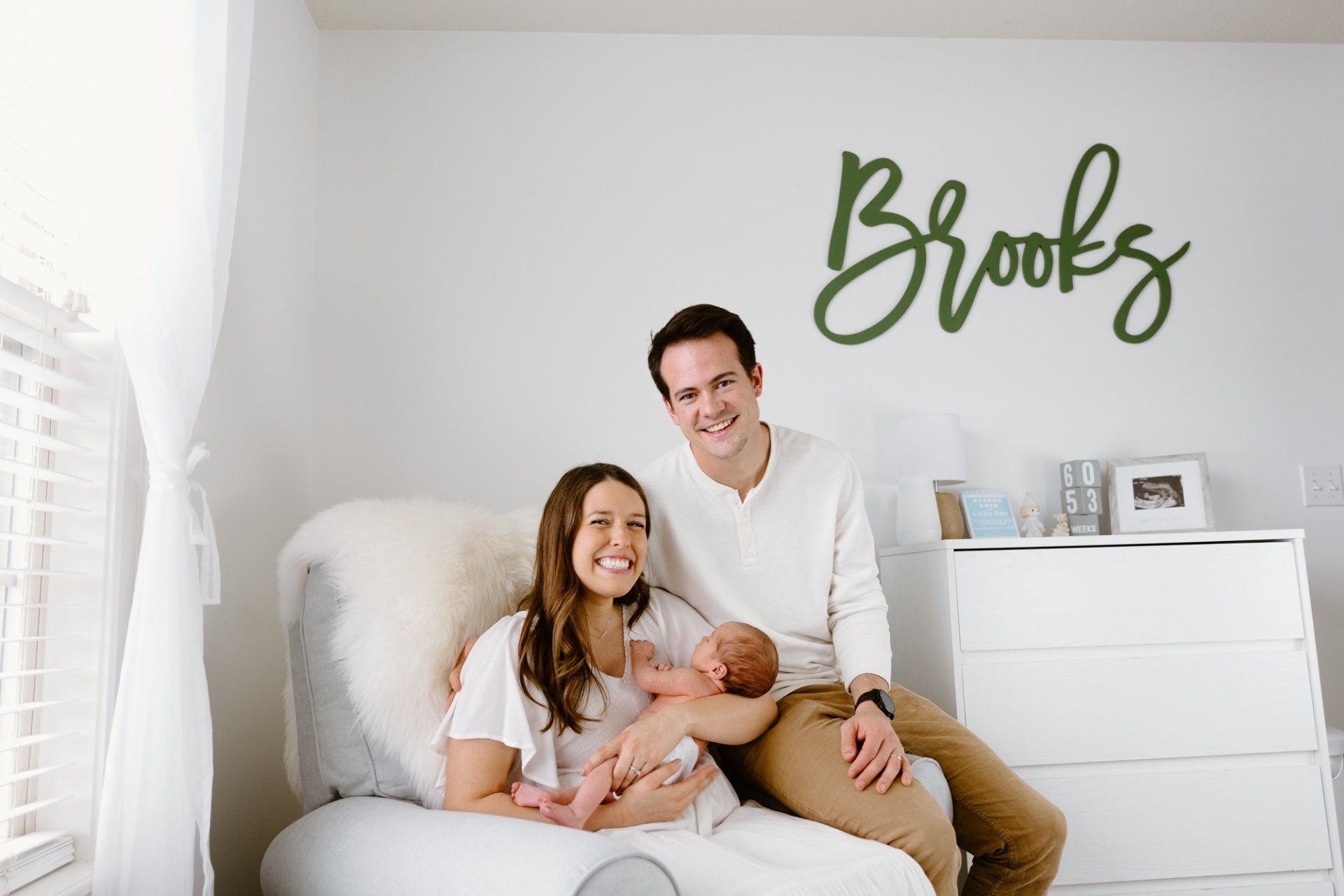 Mom and dad smile while holding newborn baby