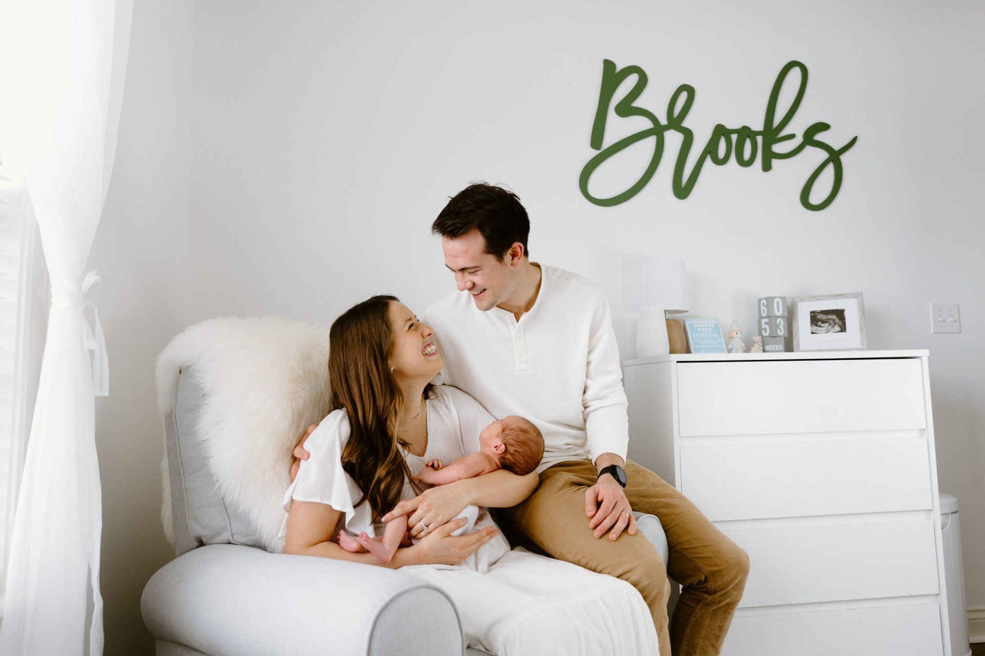 Mom and dad look at each other while holding their newborn baby