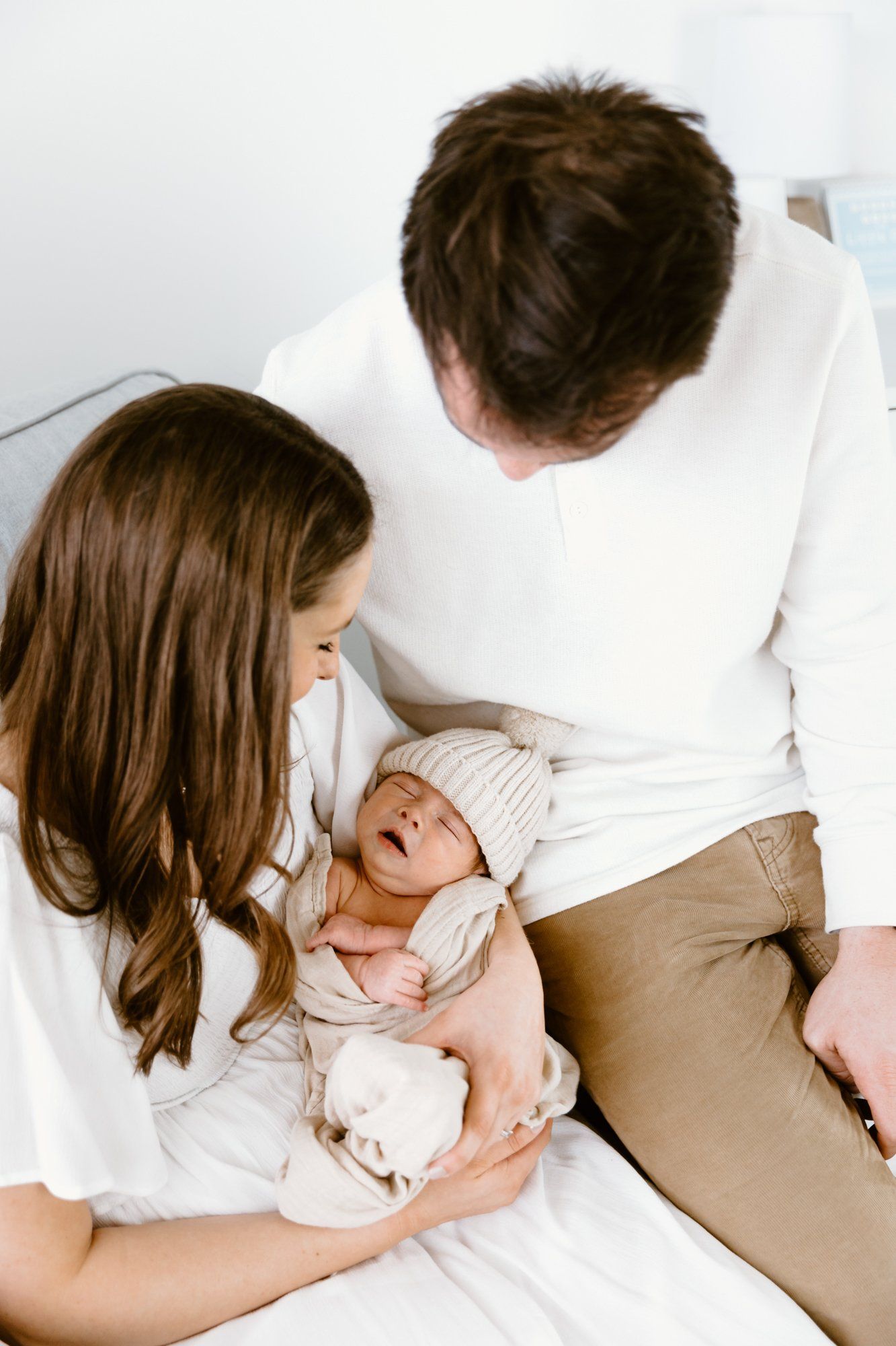 Mom and dad rock their newborn in a nursery