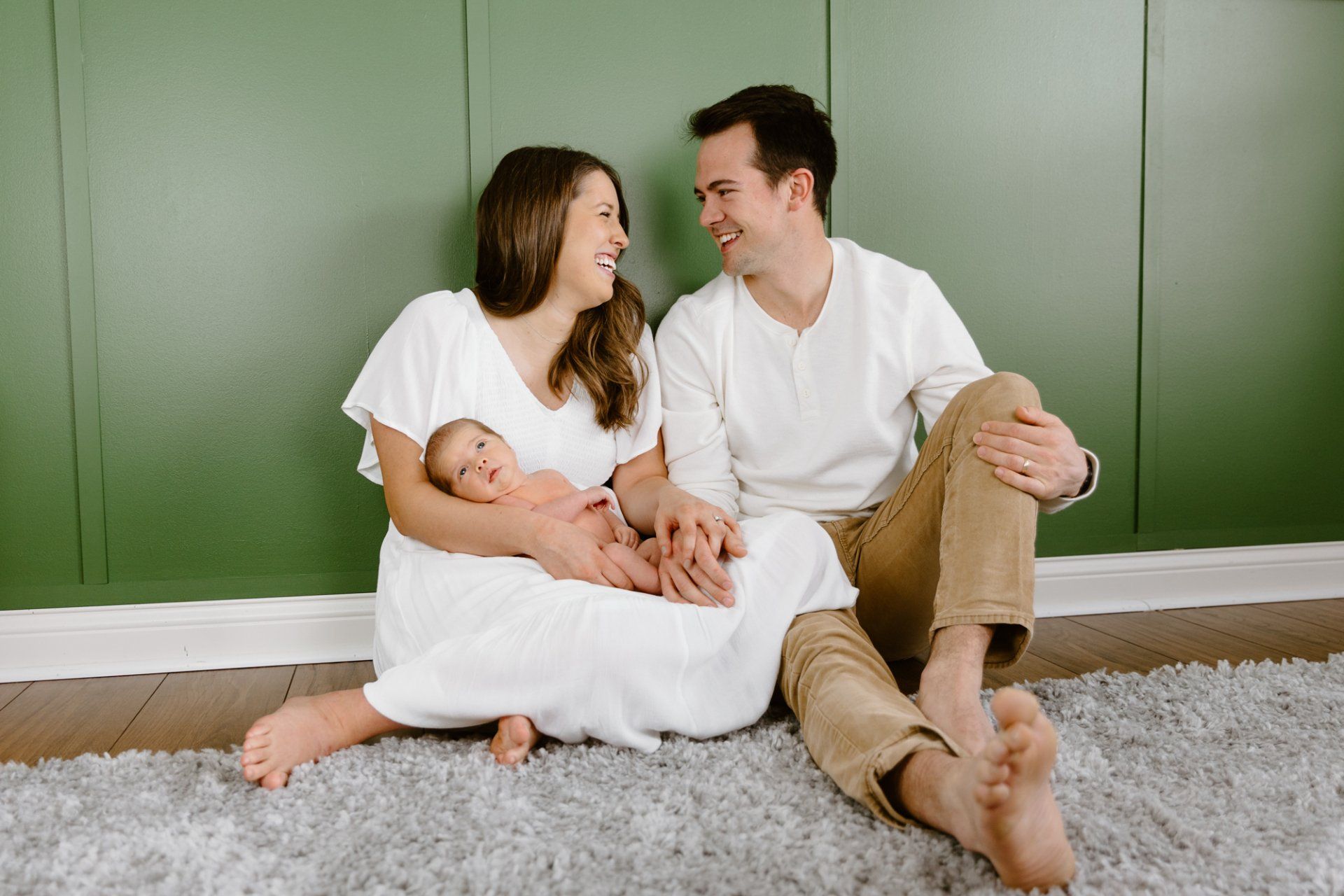 Mom and dad look at each other while sitting in the nursery