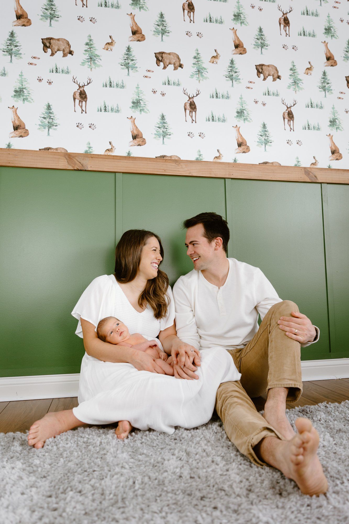 Mom and dad look at each other while holding baby in the nursery