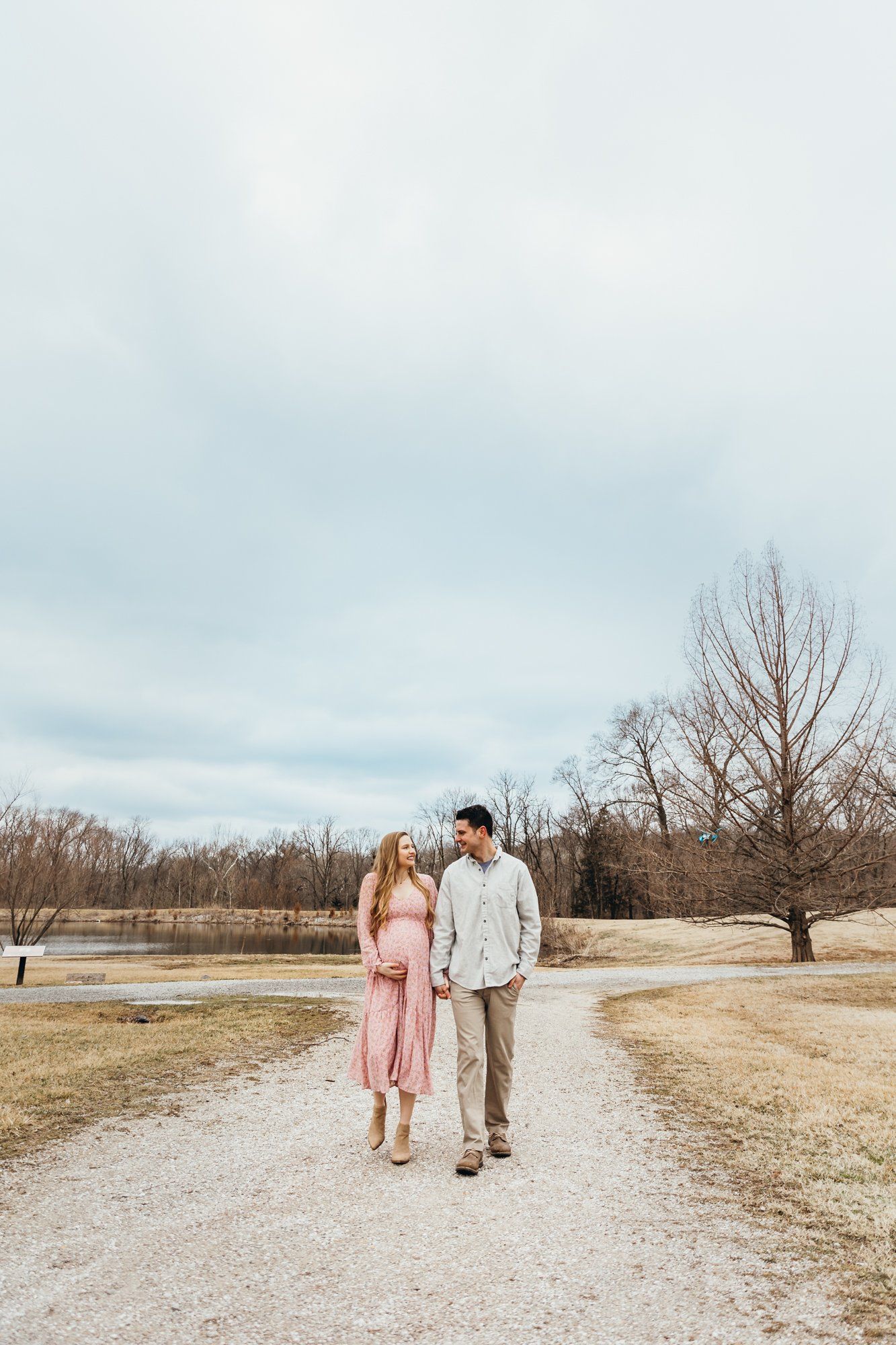 Husband and wife hold hands and walk on a trail