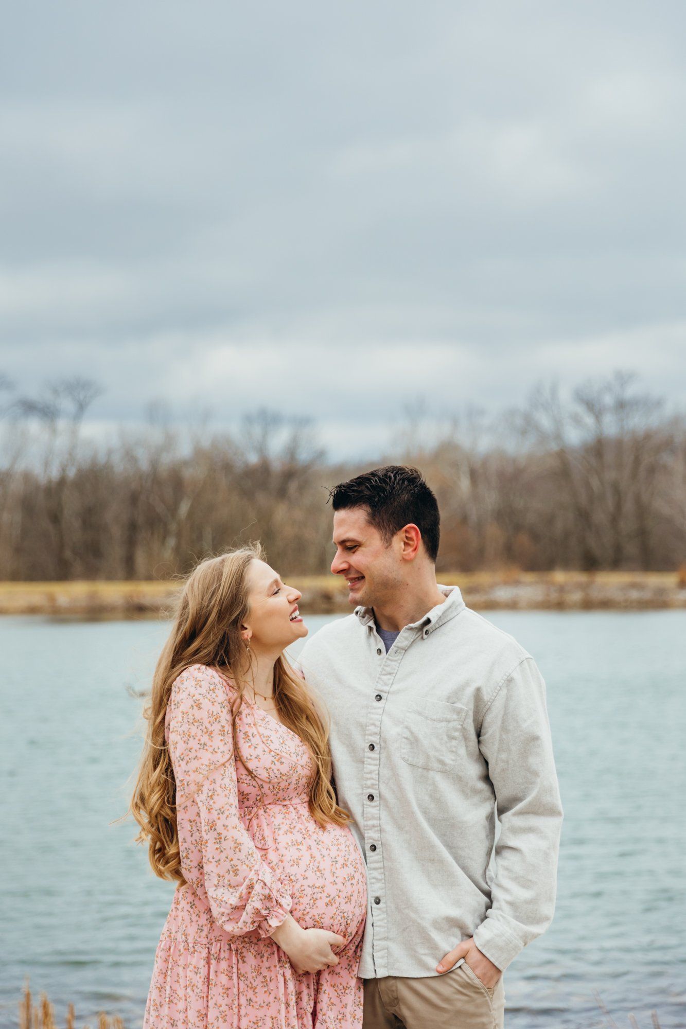 Mom holds her baby bump as dad looks at her