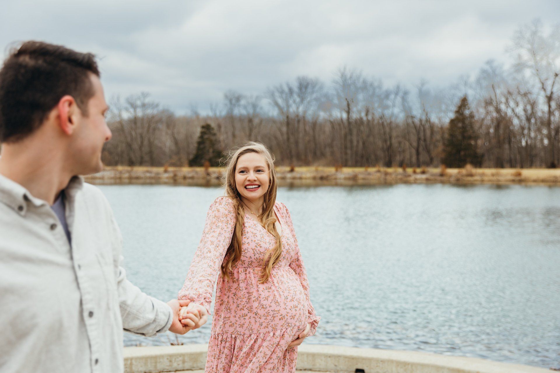 Husband leads his pregnant wife as they walk
