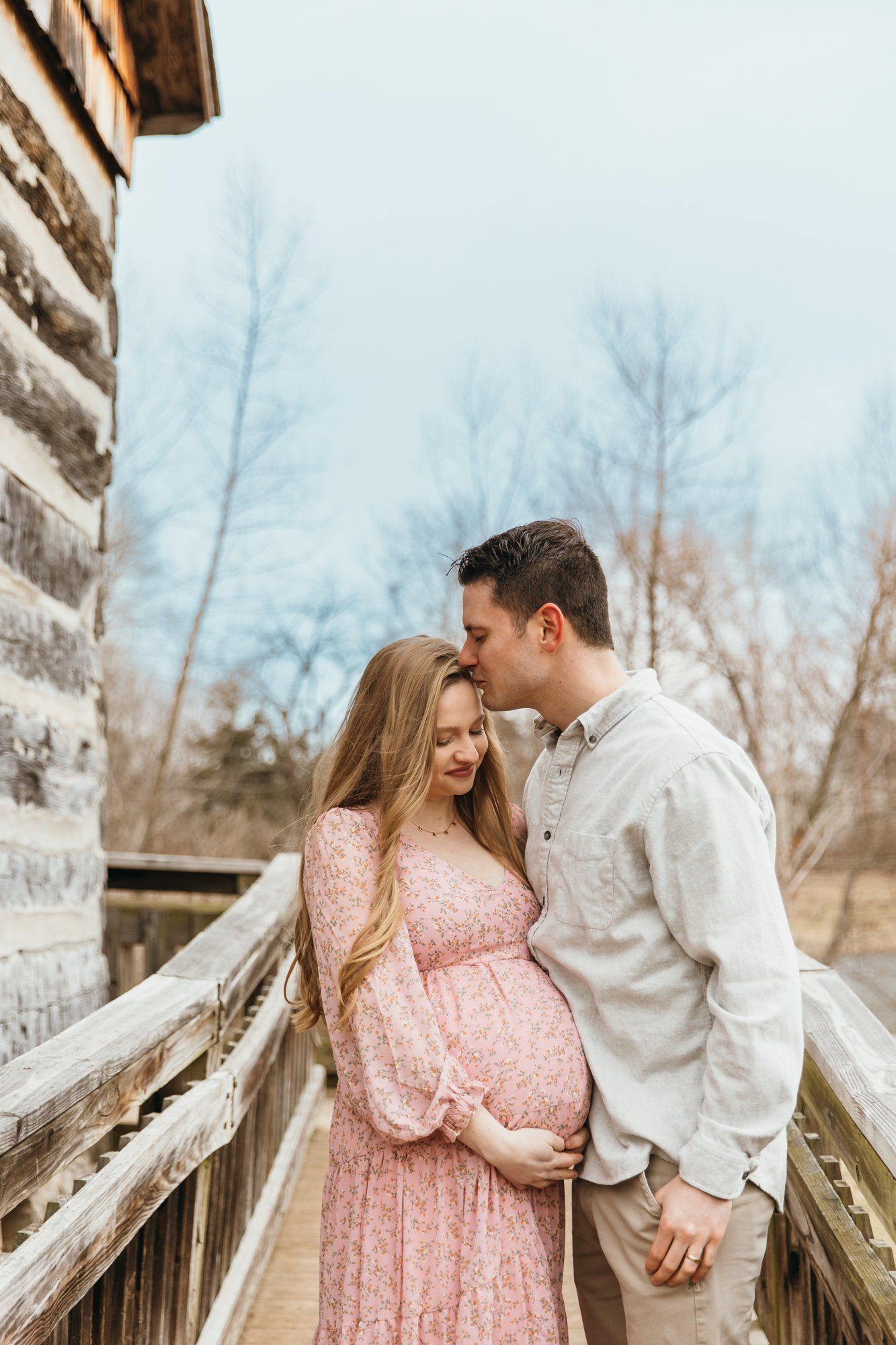 Husband kisses his pregnant wife's head