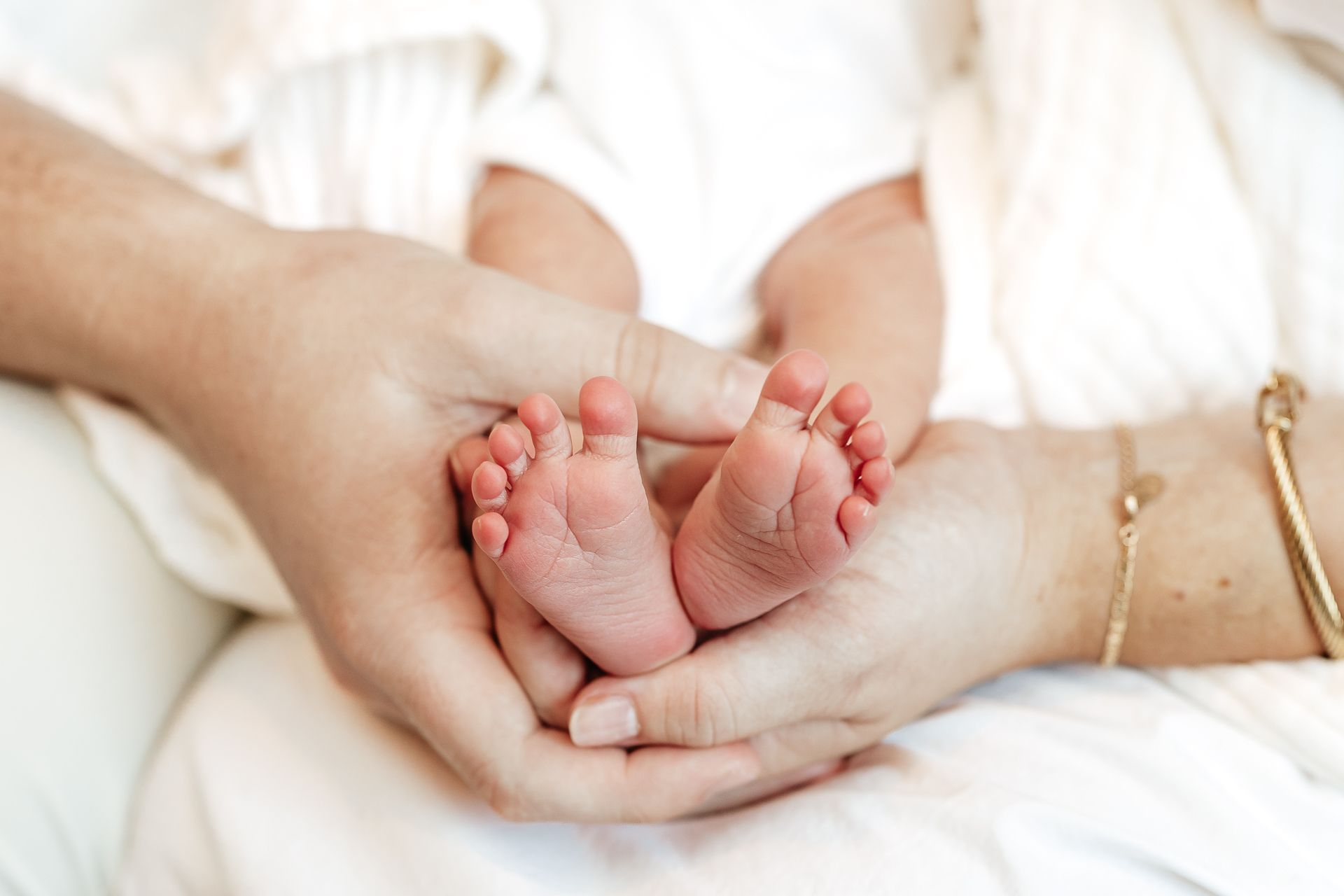 Baby's tiny feet cradled in two hands.