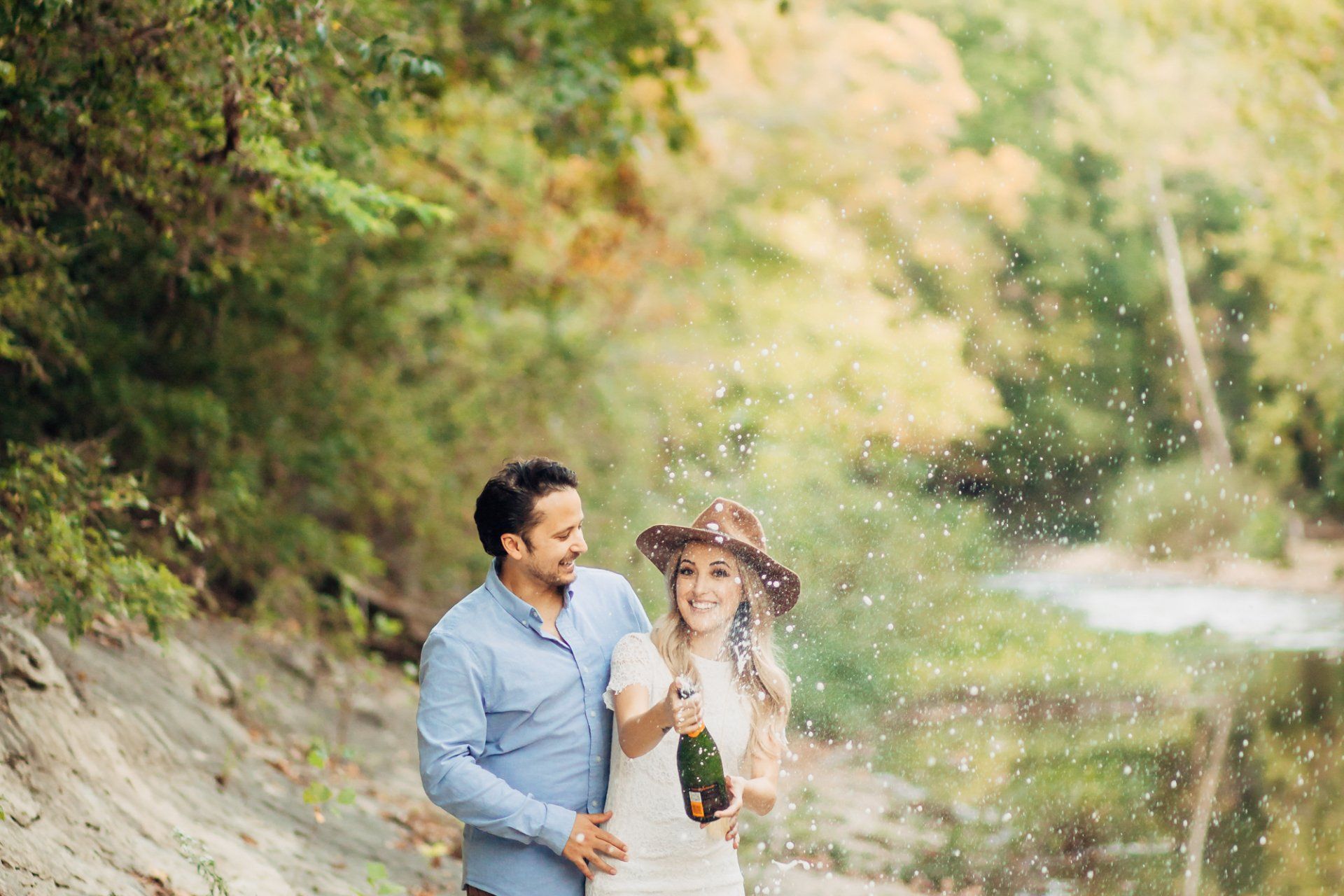 Engaged couple pops champagne