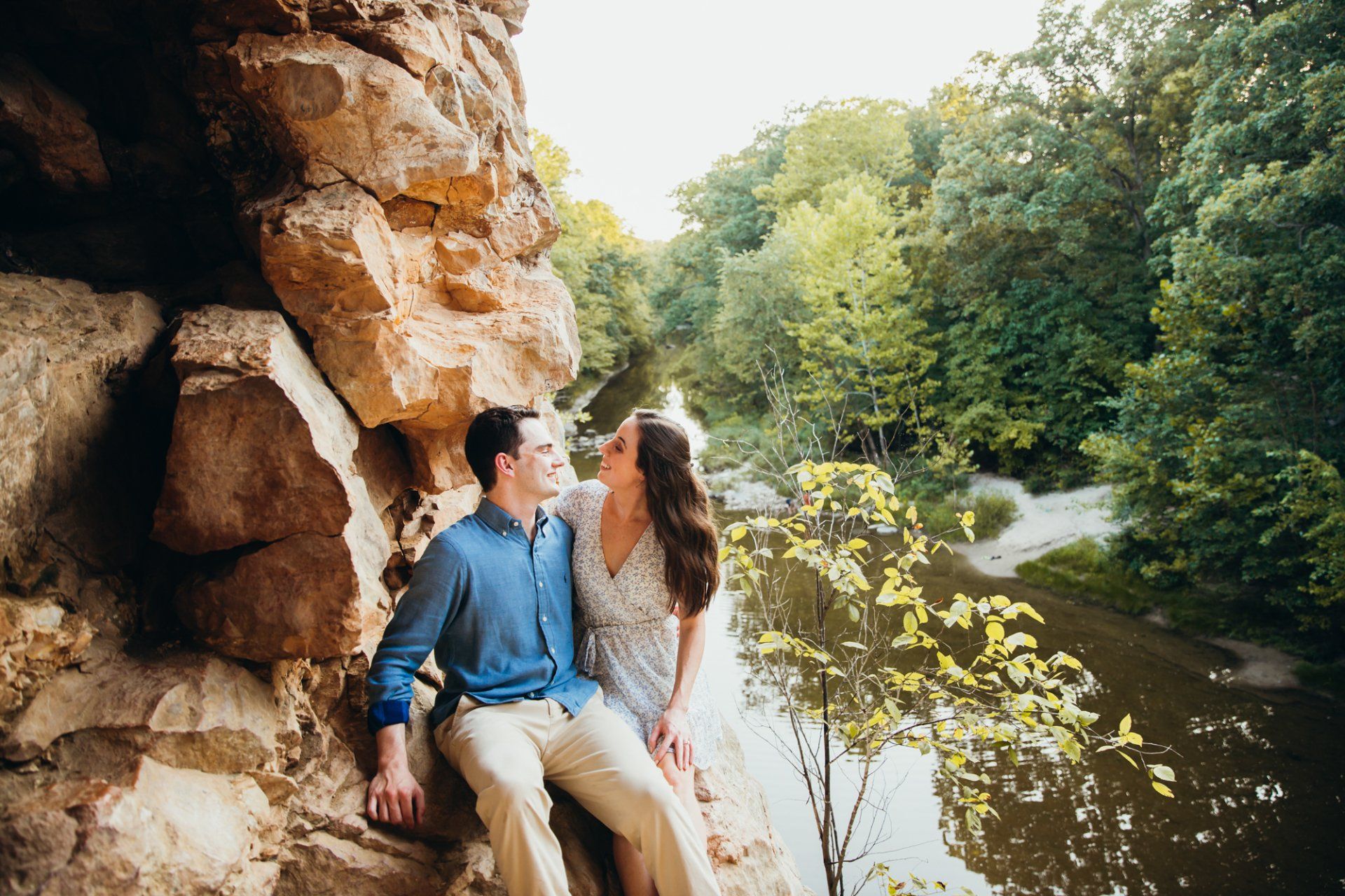 Engaged couple sits on a rock formation at The Pinnacles Youth Park