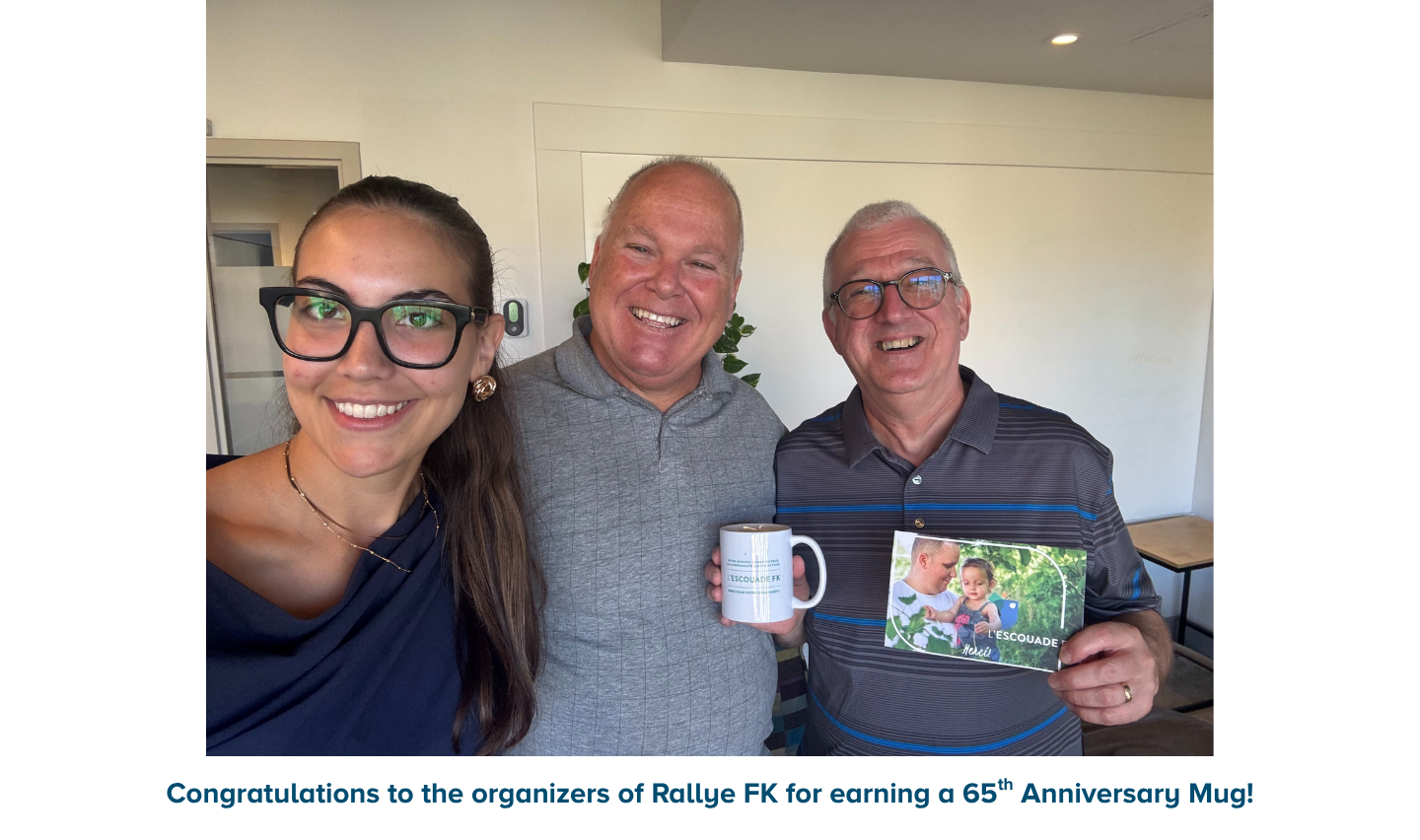Event organizers holding 65th anniversary mug and thank you card.