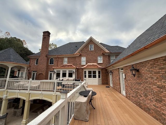 A house is being painted with ladders on the side of it.