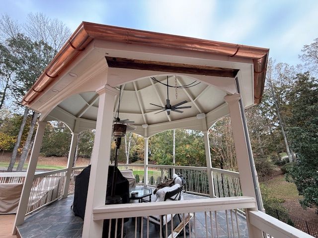 A man is standing on a ladder on the side of a house.
