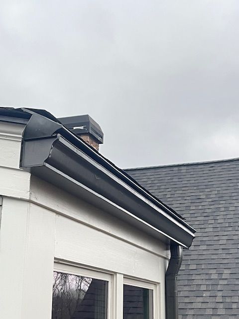 A close up of a gutter on the roof of a house.