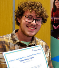 A young man wearing glasses is holding a certificate that says ' villiers park future leaders programme ' on it