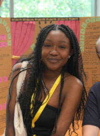 A woman wearing a black top with a yellow lanyard around her neck