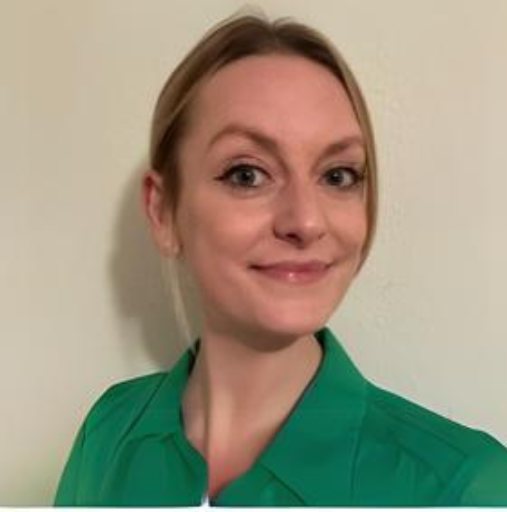 A woman in a green shirt is smiling for the camera