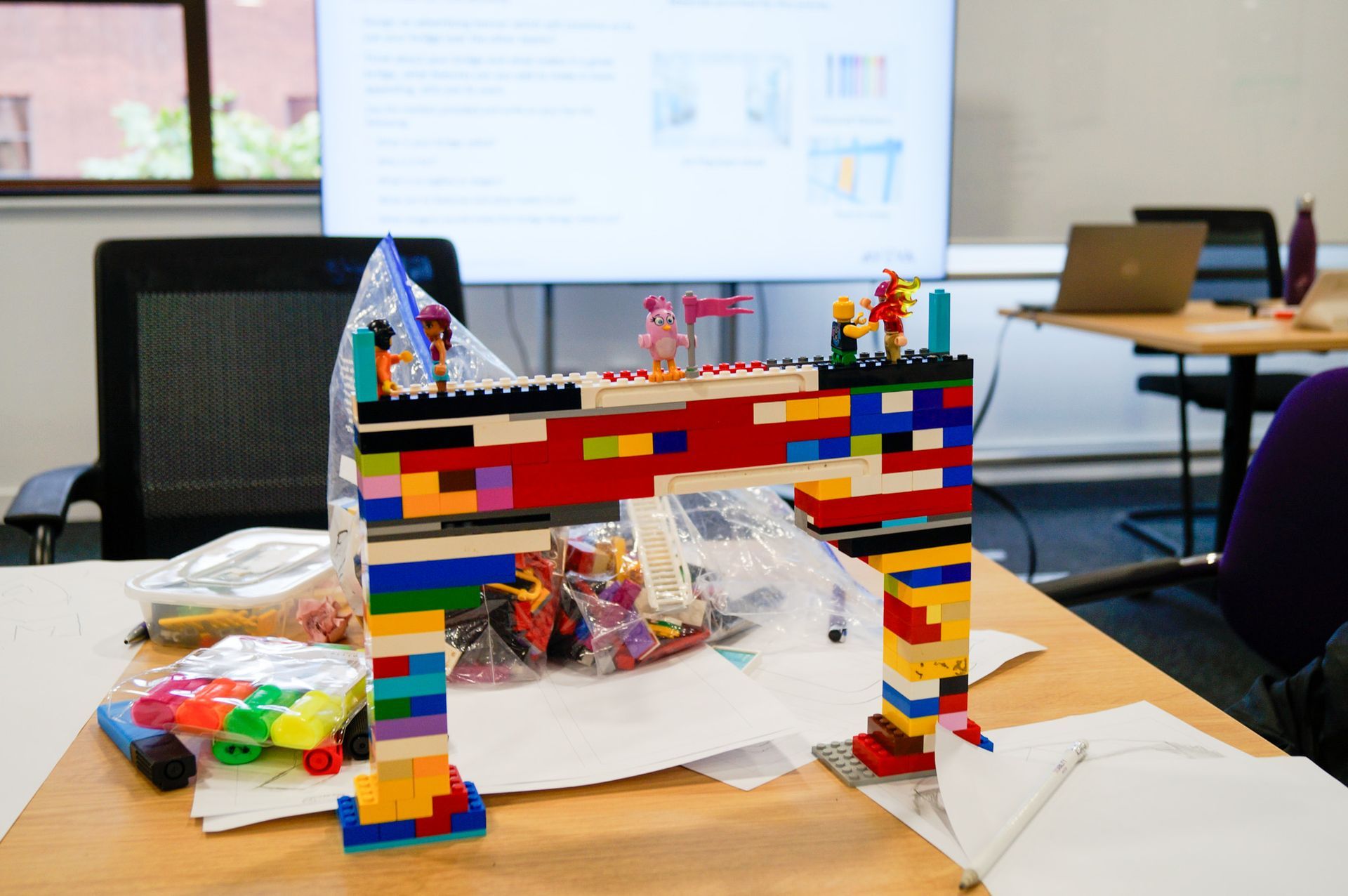 A lego bridge is sitting on top of a wooden table.
