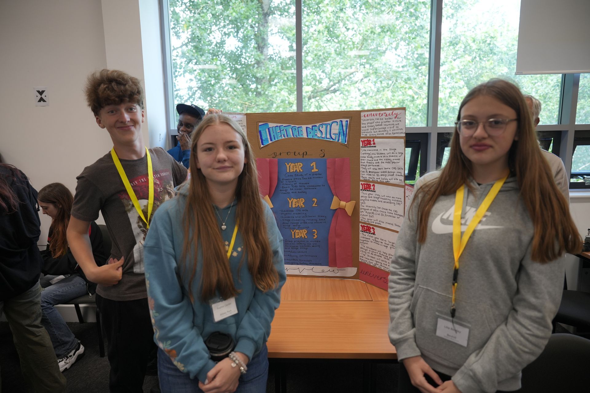 A group of young people are standing in front of a project in a classroom.