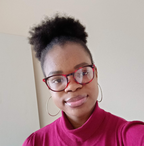 A woman wearing glasses and hoop earrings is taking a selfie.