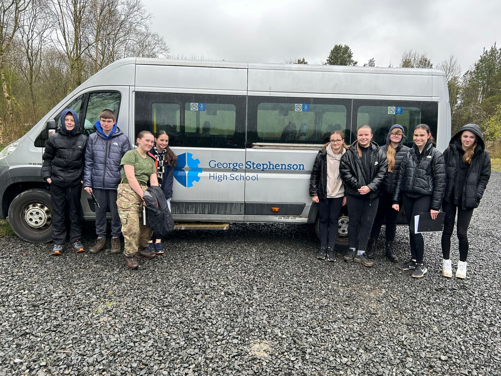 A group of people are standing in front of a van.