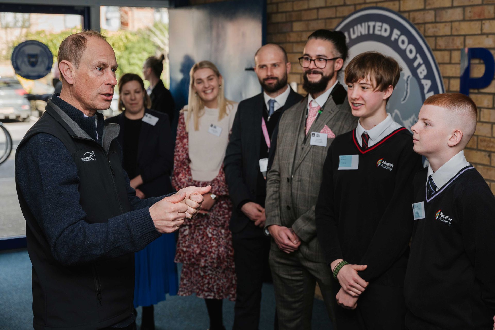 A man is talking to a group of people in a room.