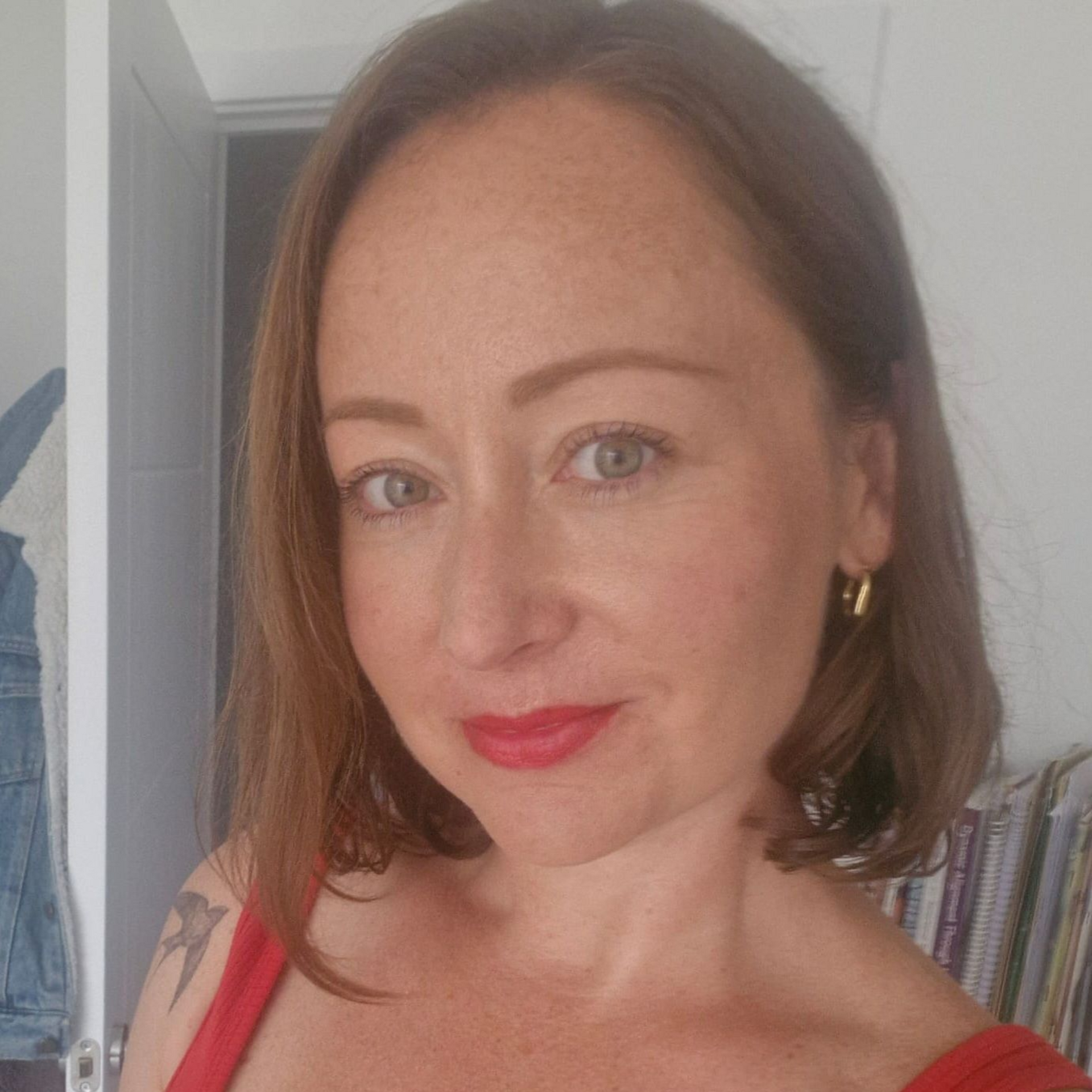 A man with a beard is smiling and wearing a purple shirt