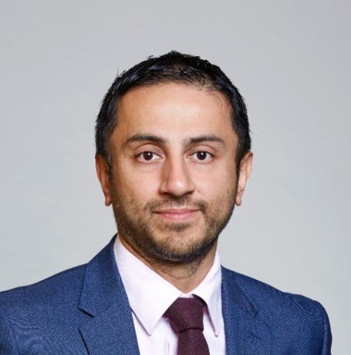 A man in a suit and tie is smiling for the camera
