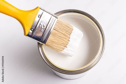 A person is painting a yellow wall with a paint roller.