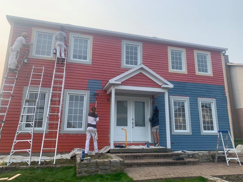 A group of people are painting a blue house.