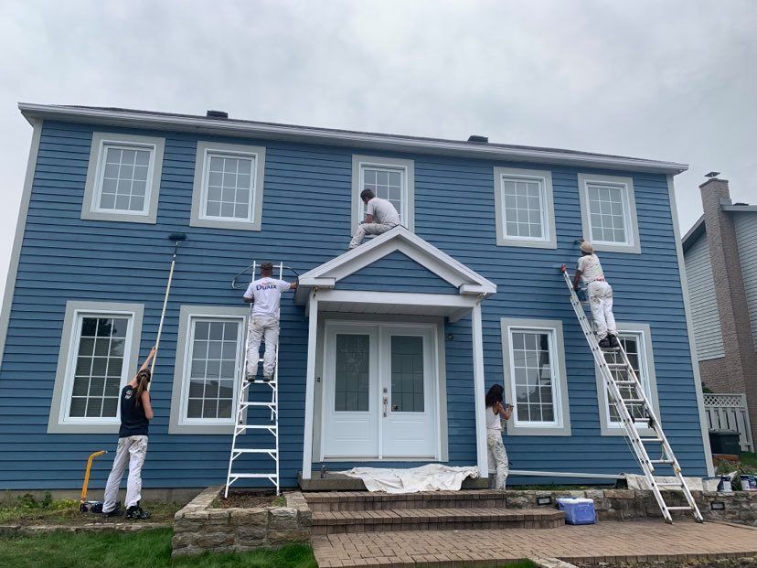 A group of people are painting a house red and blue.