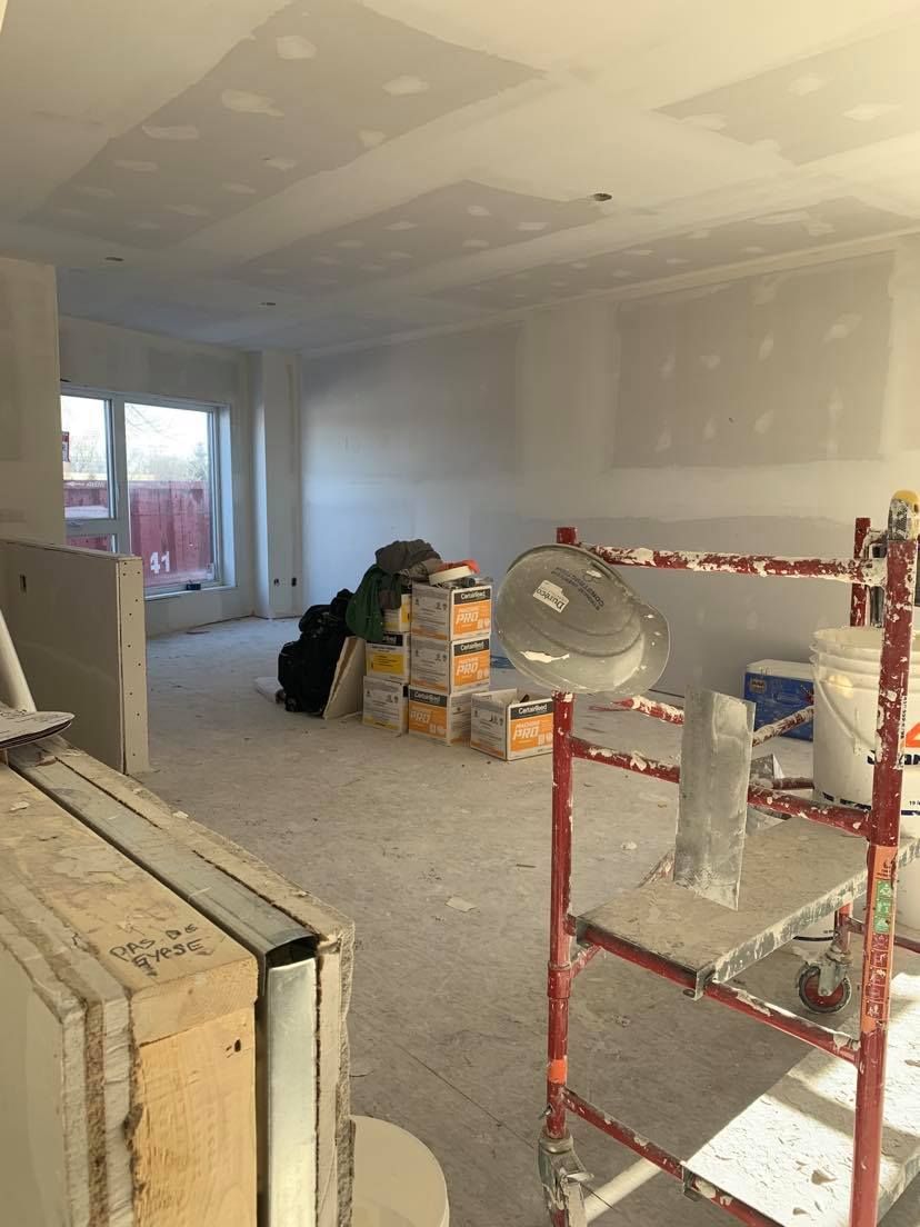 A room with a lot of boxes on the floor and a scaffolding.