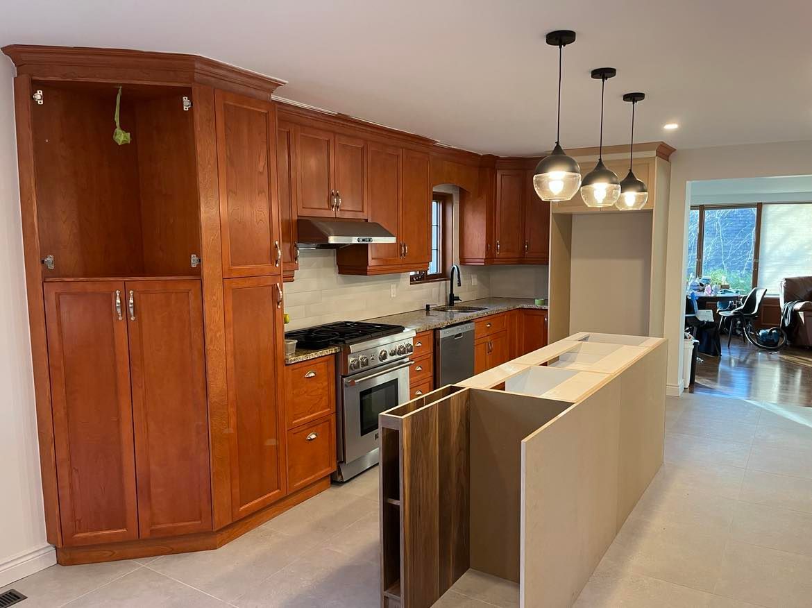 A kitchen with wooden cabinets , a stove , and a large island.