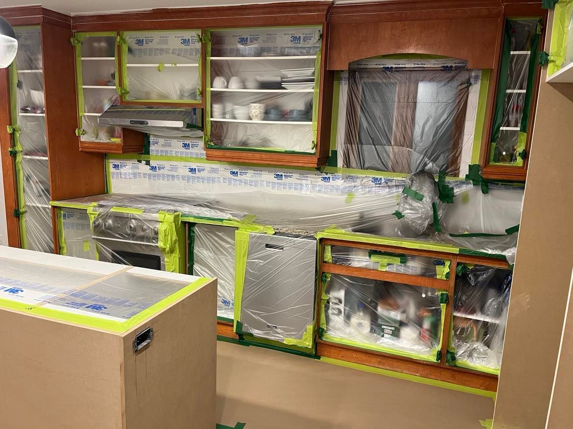 A kitchen is being painted and covered in plastic.