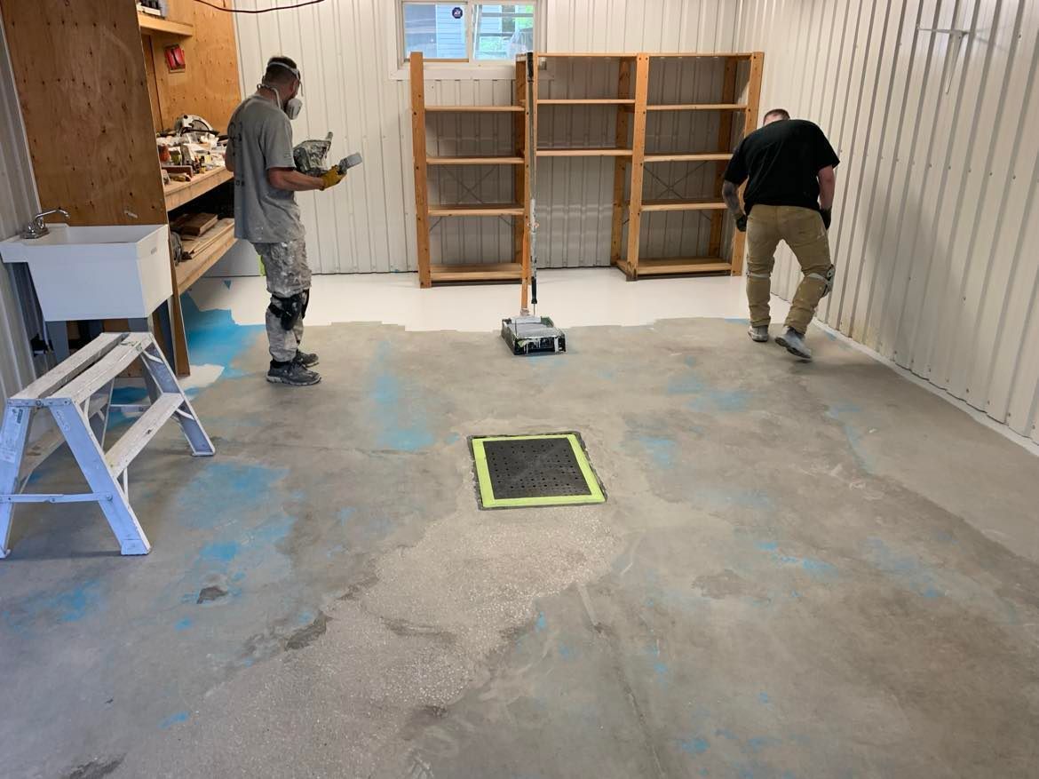 A man is standing on a ladder painting the side of a house.