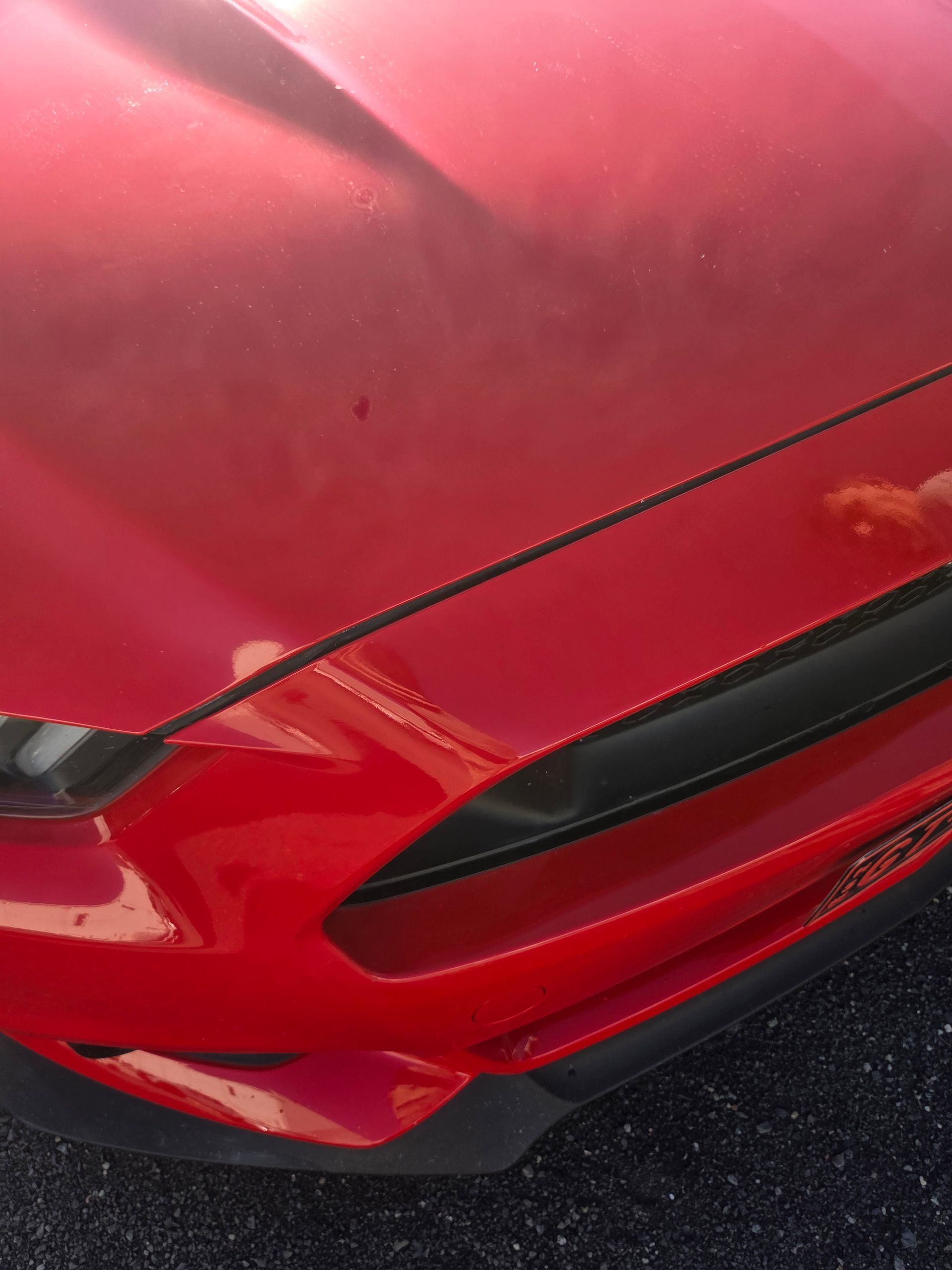 Close-up of a red car’s front bumper with a black grille and visible scratch damage — A2B Smash Repairs in Berkeley Vale, NSW