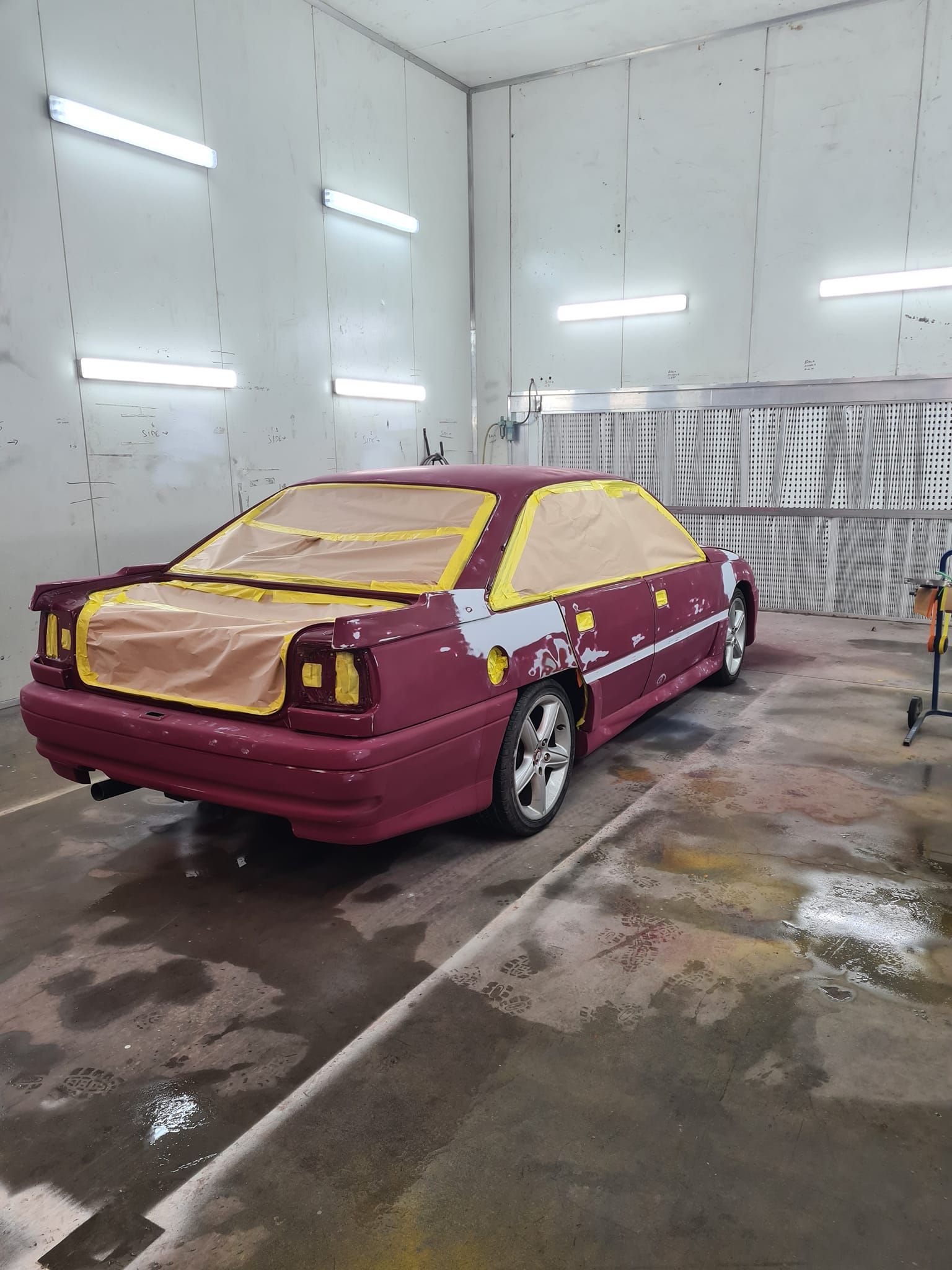 Maroon Sedan in a Paint Booth, Masked — A2B Smash Repairs in Wyong, NSW