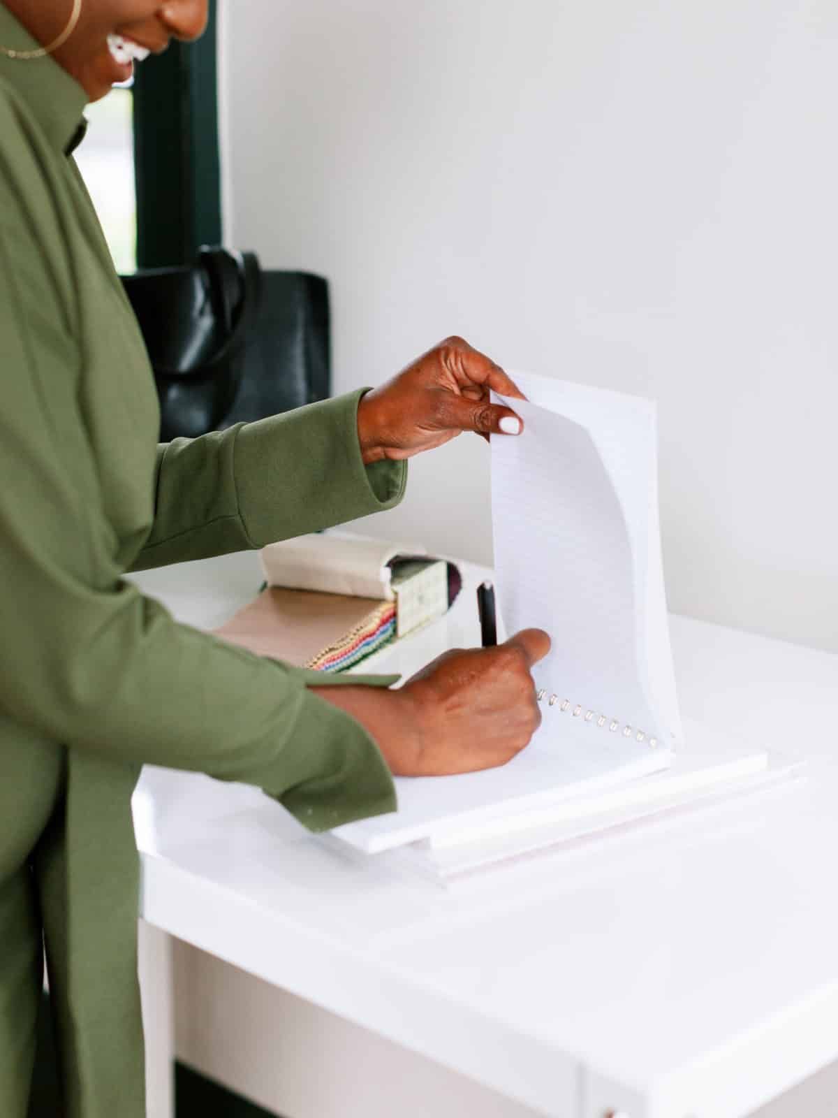 Person placing paper into a white ballot box on a desk