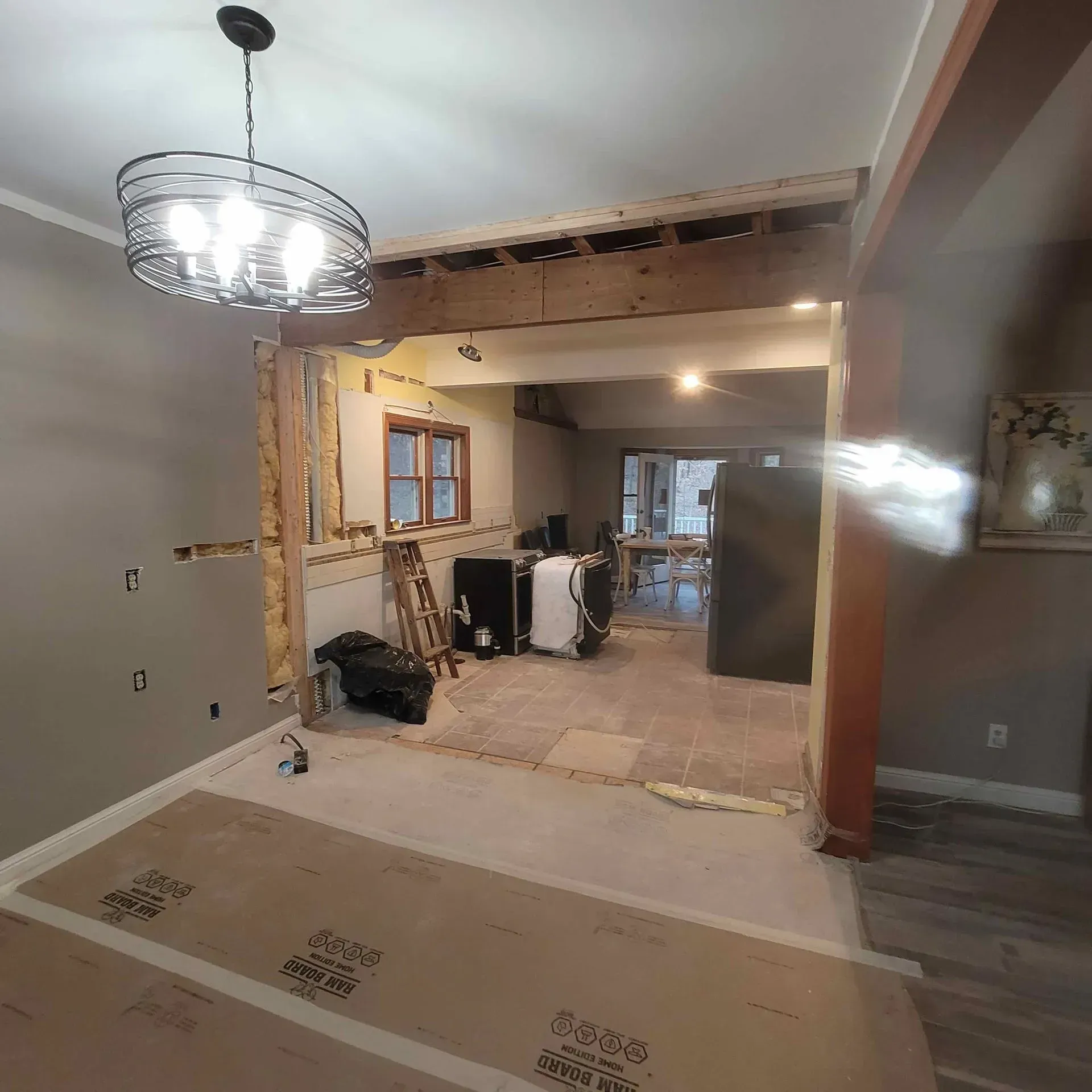 A room that is being remodeled with a chandelier hanging from the ceiling.