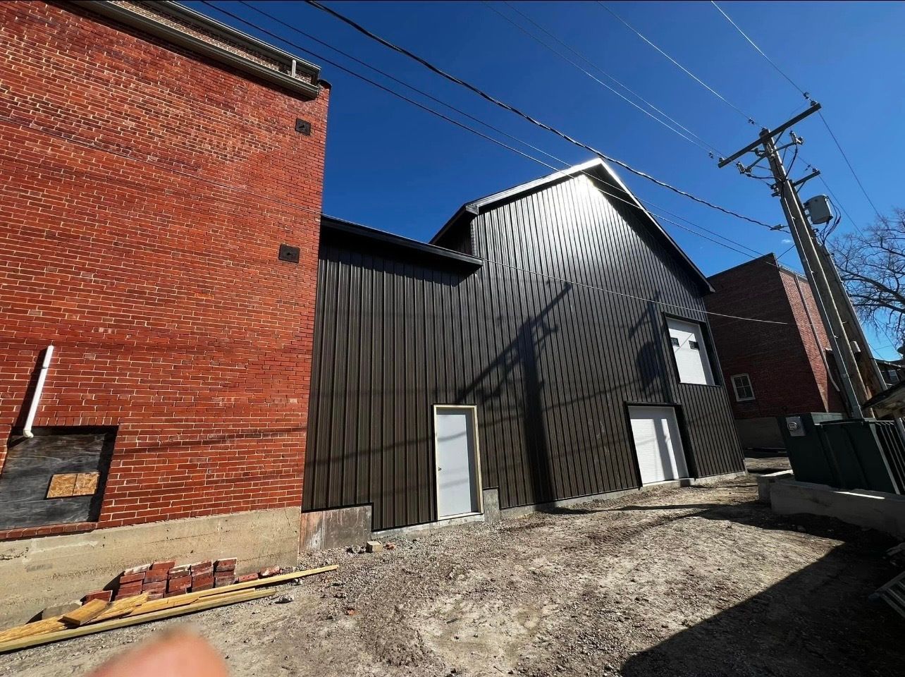 A person is standing in front of a building that is being remodeled.