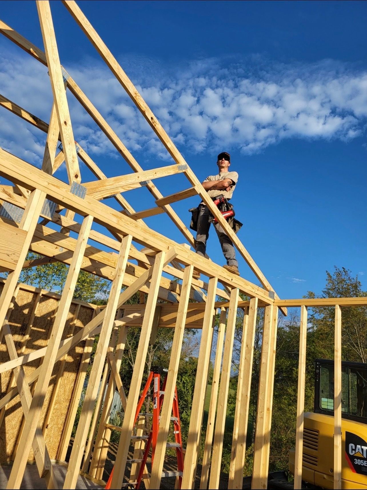 A man is standing on top of a wooden structure under construction.