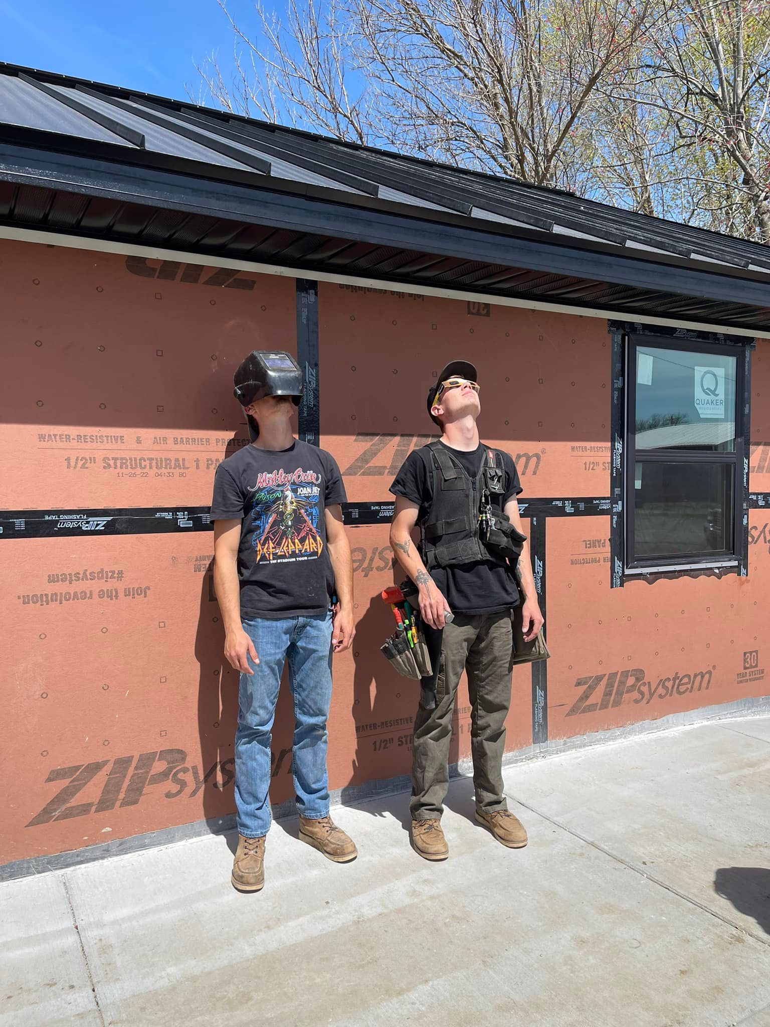 Two men are standing in front of a building that is being built.